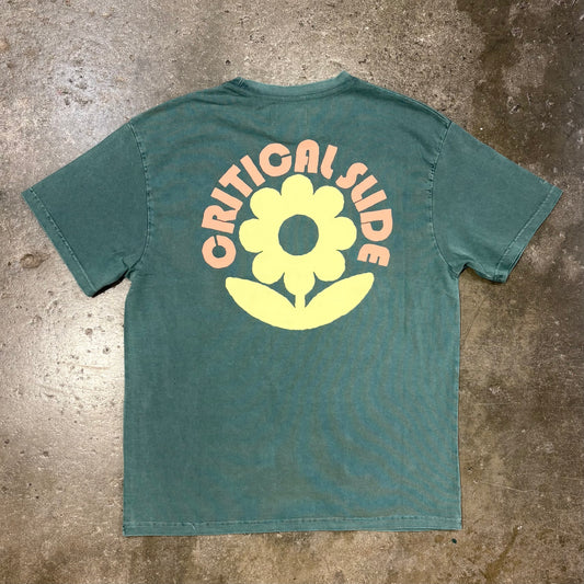 Green t-shirt with 'Critical Slide Society' logo on a concrete surface