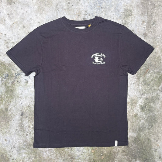 A black short-sleeve crewneck t-shirt with a small white graphic on the left chest, laid flat on a textured concrete surface.