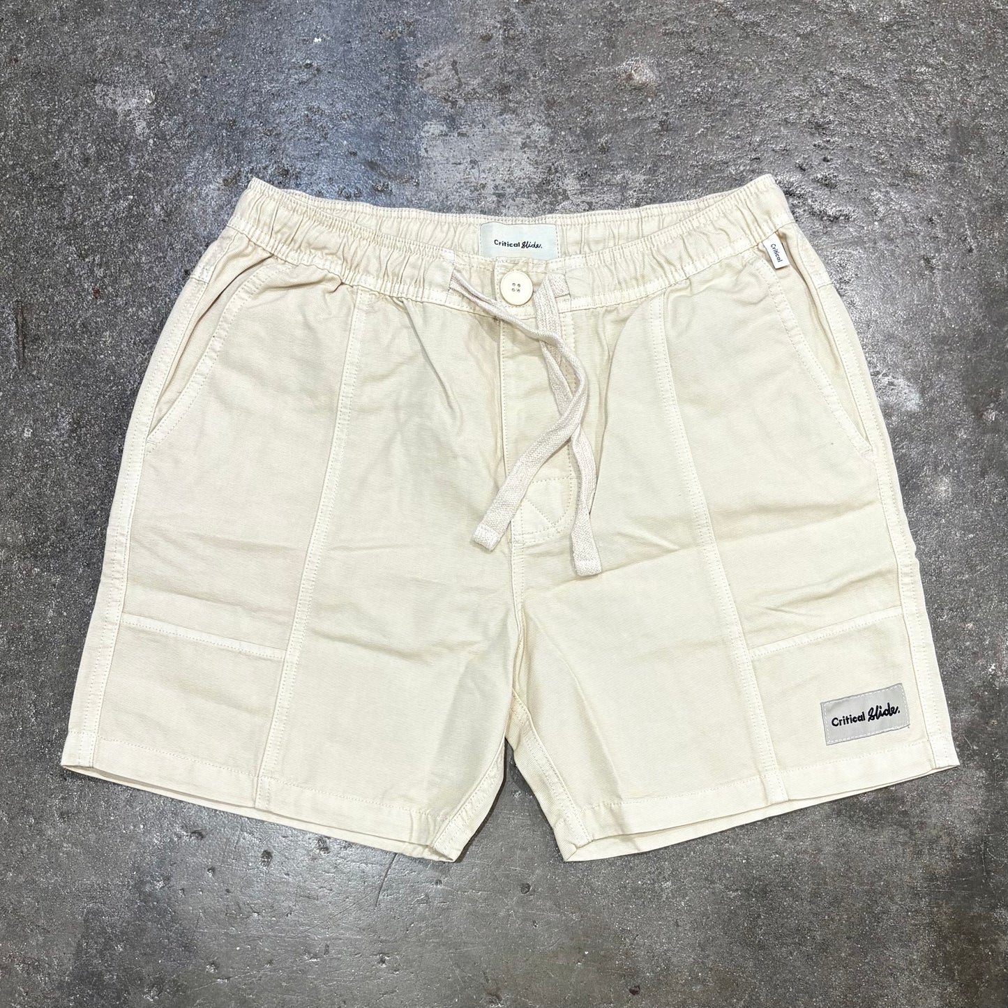 Beige shorts on a gray concrete surface