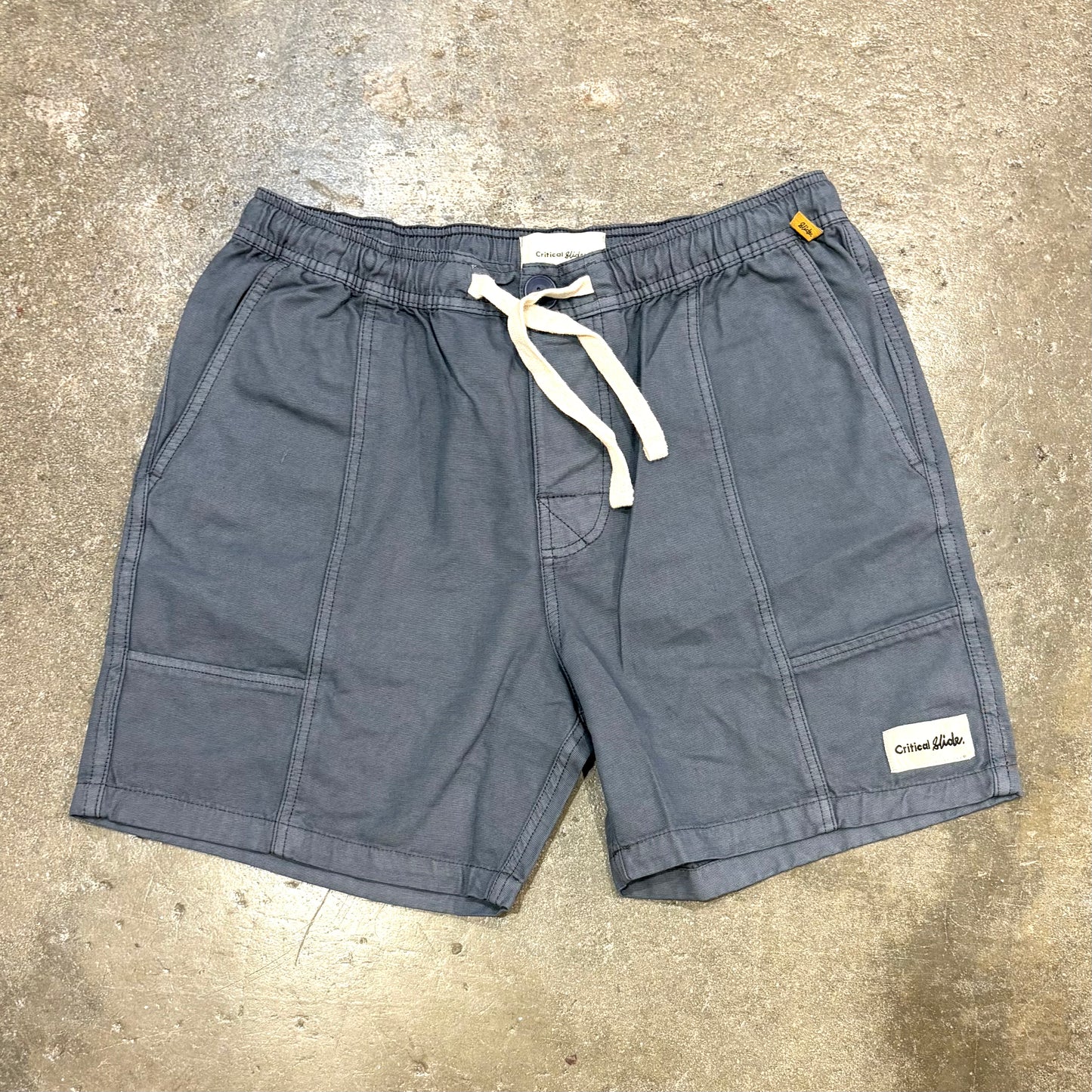 Gray shorts with a drawstring on a concrete surface