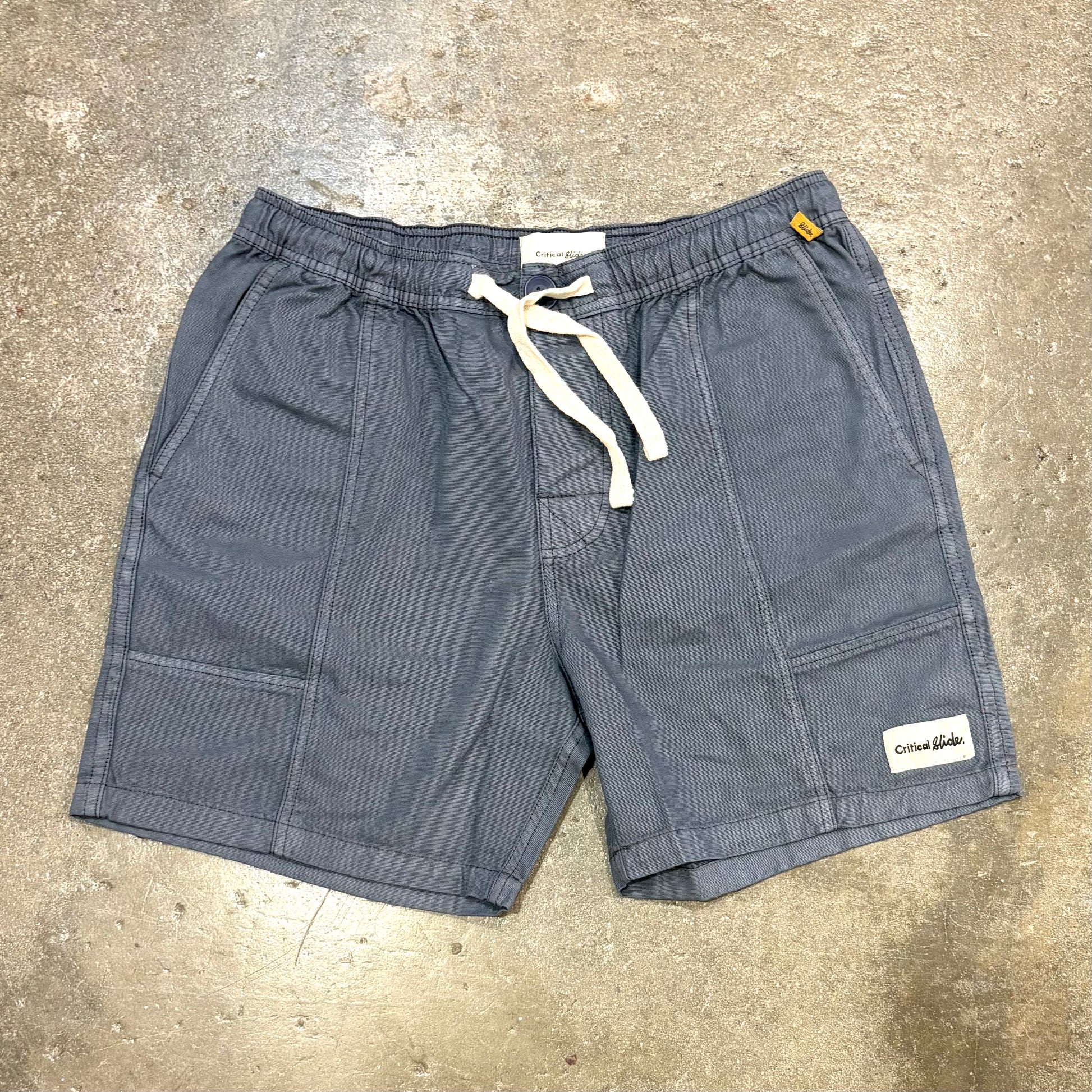 Gray shorts with a drawstring on a concrete surface