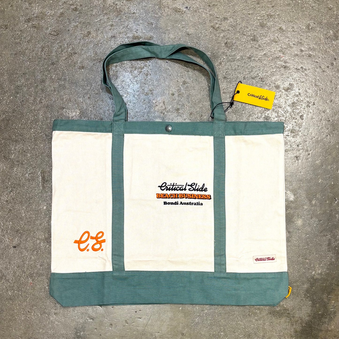 Tote bag with visible branding on a concrete surface