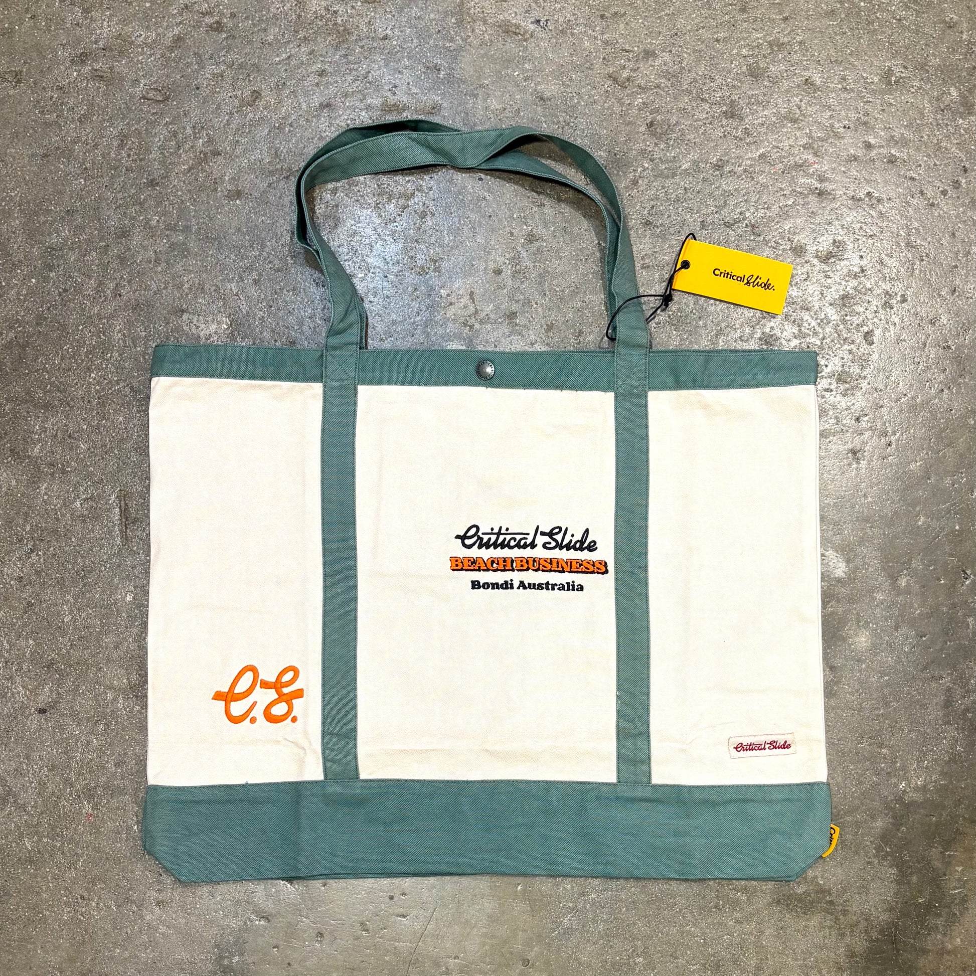 Tote bag with visible branding on a concrete surface