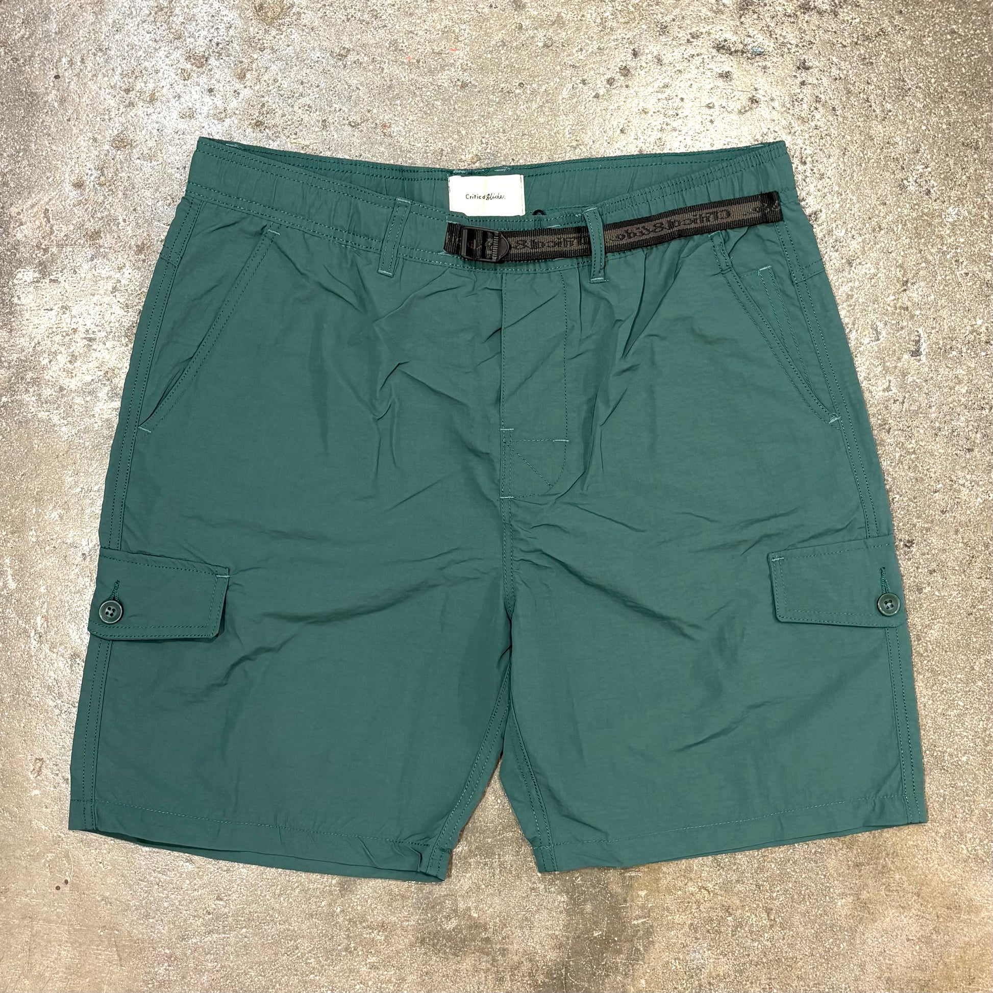 Green shorts with a belt on a textured surface
