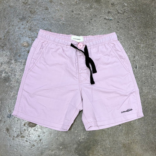 Light purple shorts with a black drawstring on a concrete surface