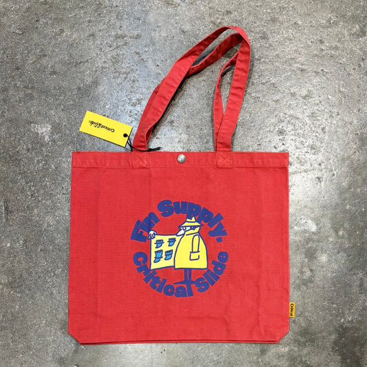 Red tote bag with a logo and text on a concrete surface