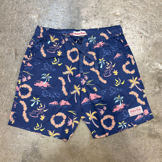 Navy blue shorts with tropical pattern on a concrete floor