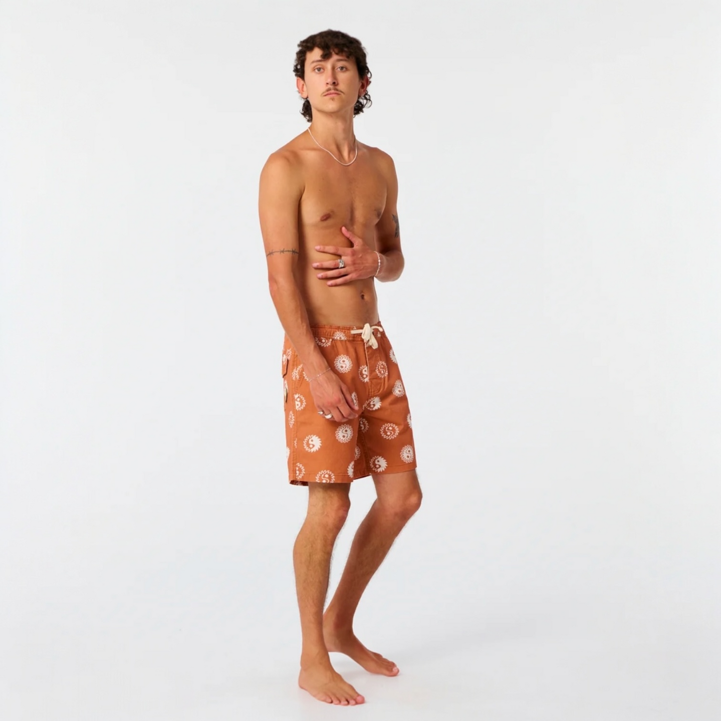 Man wearing brown patterned shorts on a white background