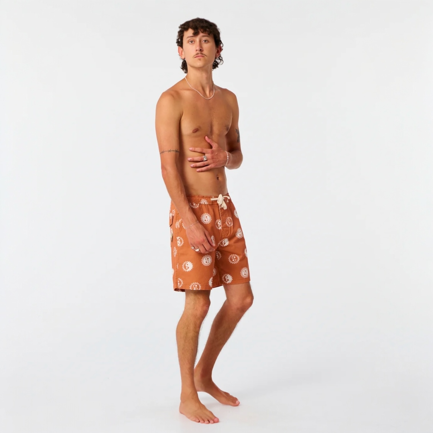 Man wearing brown patterned shorts on a white background