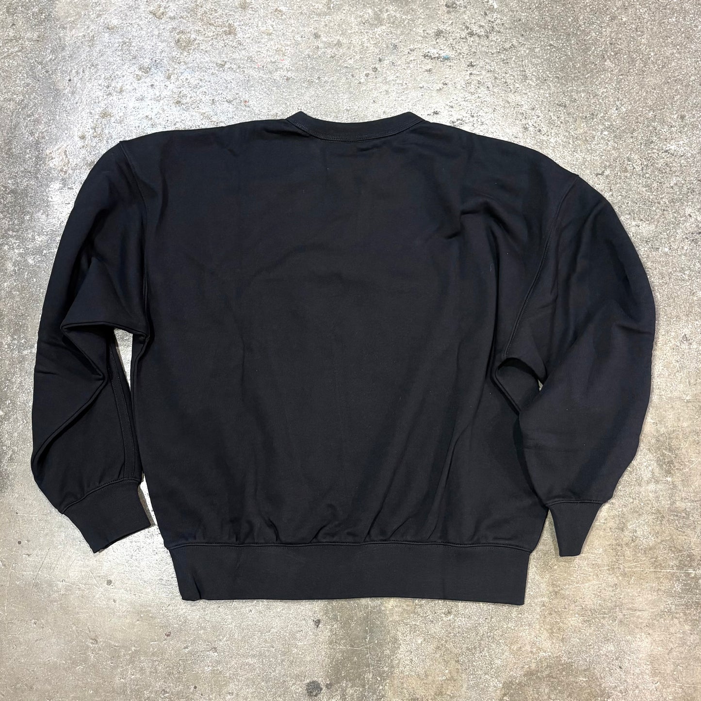 Black sweatshirt on a concrete floor