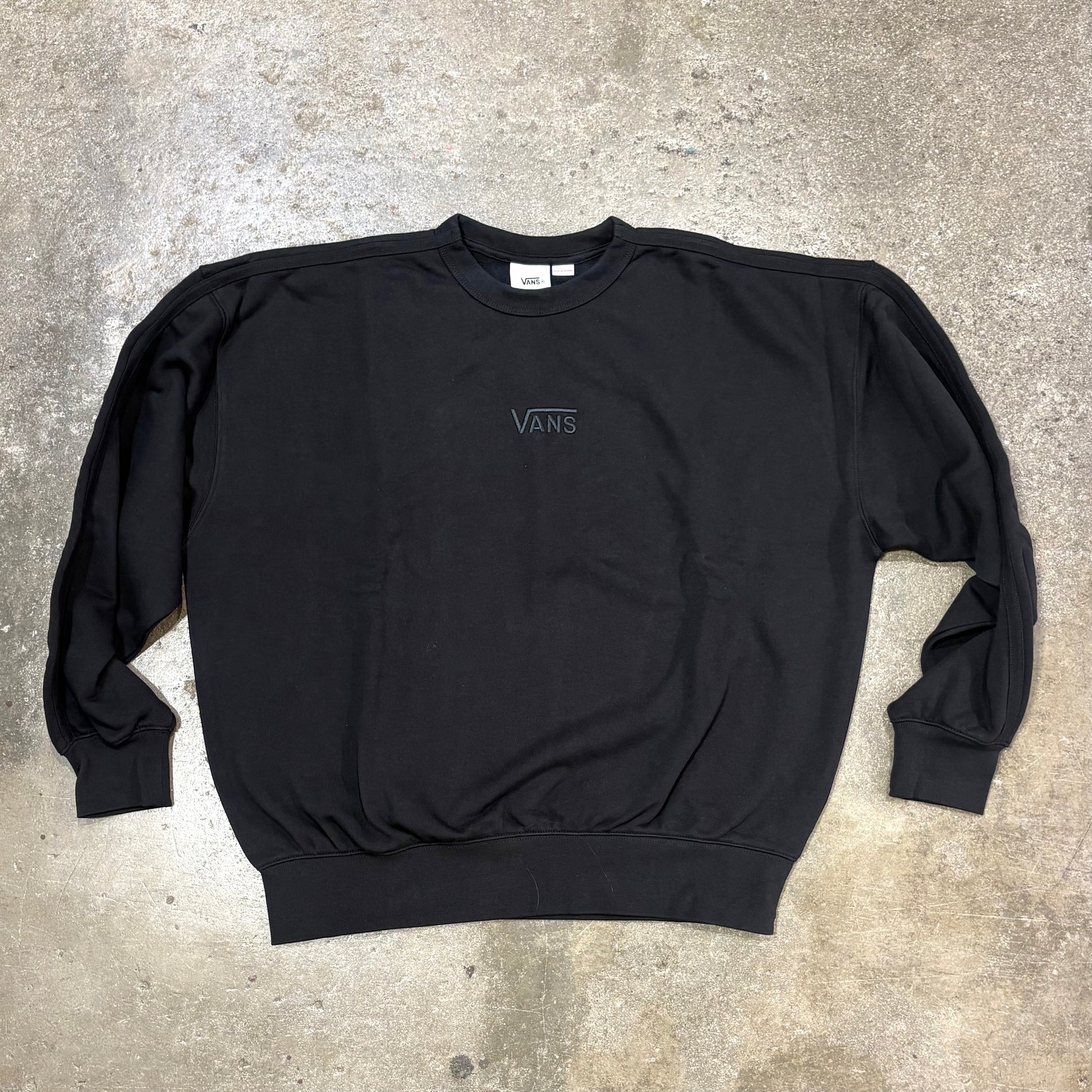 Black sweatshirt with a logo on a concrete surface