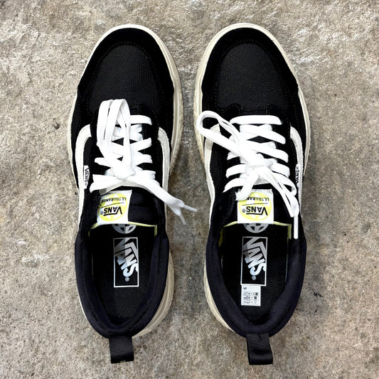 Pair of black VANS   ULTRARANGE NEO VR3 sneakers with white laces on a concrete surface