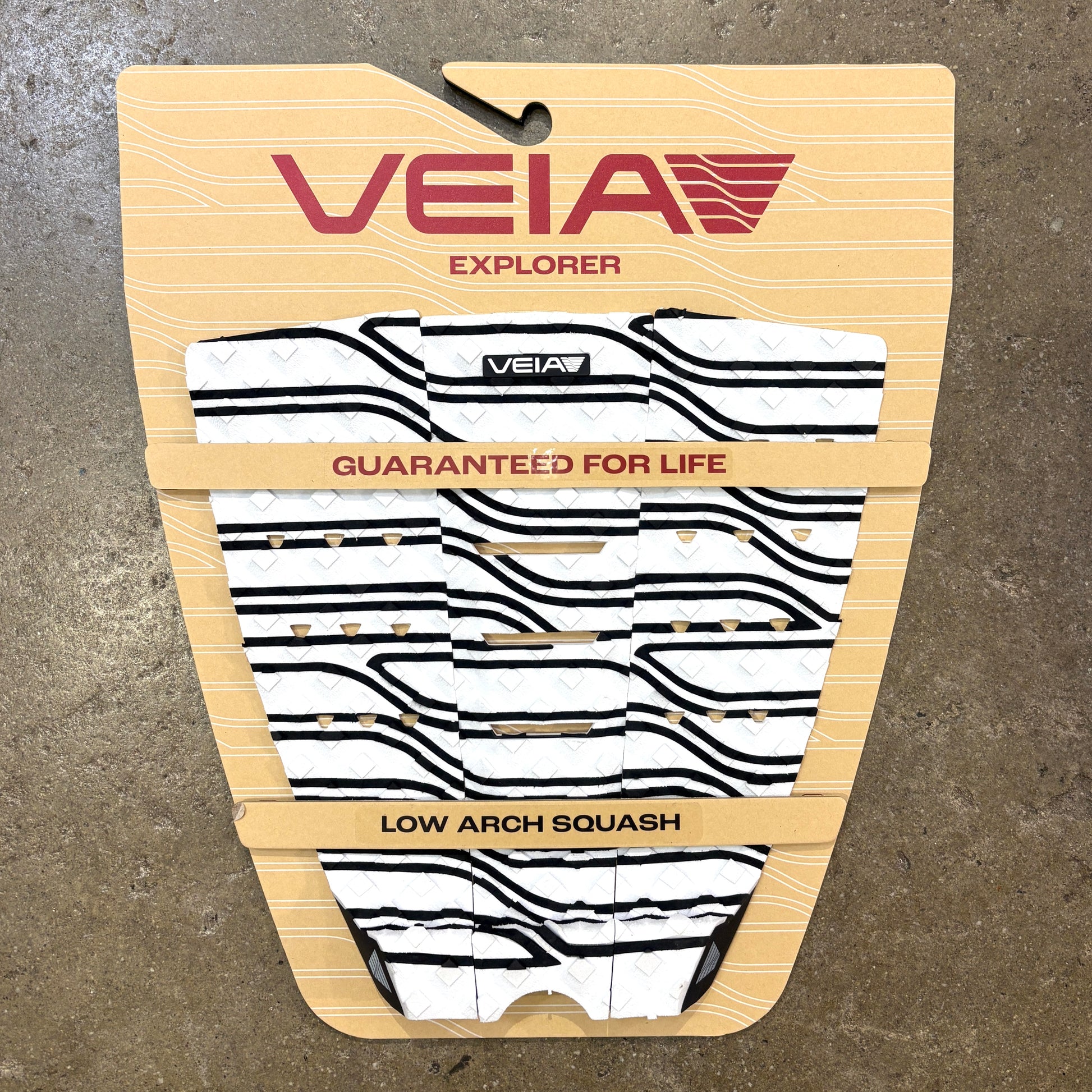 VEIA Explorer low arch swim board deck pad in white and black wavy pattern with tan backing, displayed on a concrete floor.