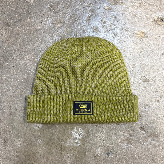 Green knit beanie with a Vans label on a concrete surface