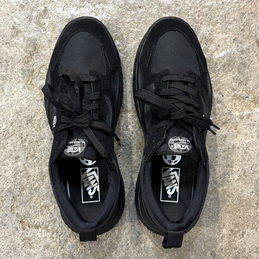 Pair of black Vans Ultrarange Neo Black/Black sneakers on a textured surface.