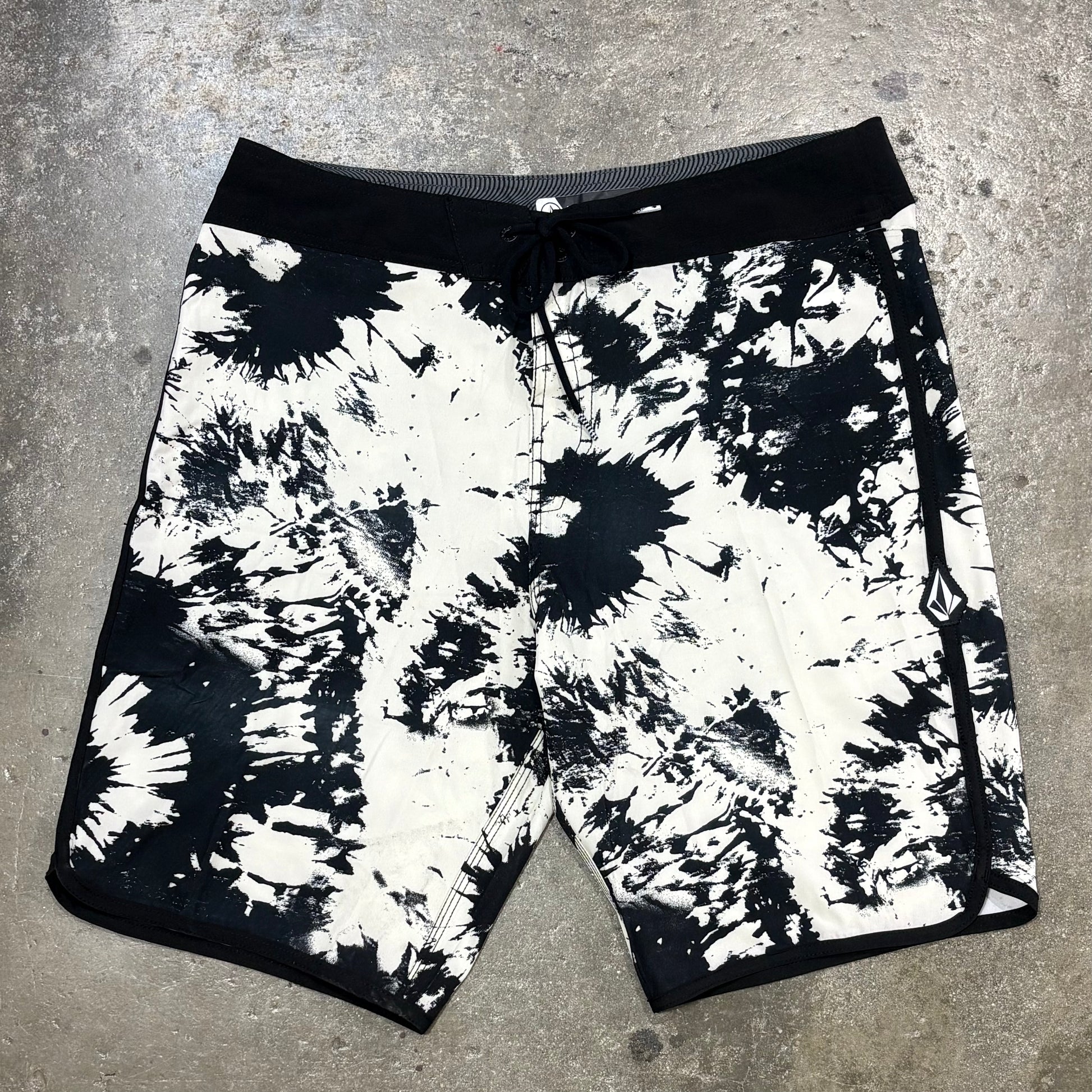 Black and white tie-dye shorts on a concrete surface