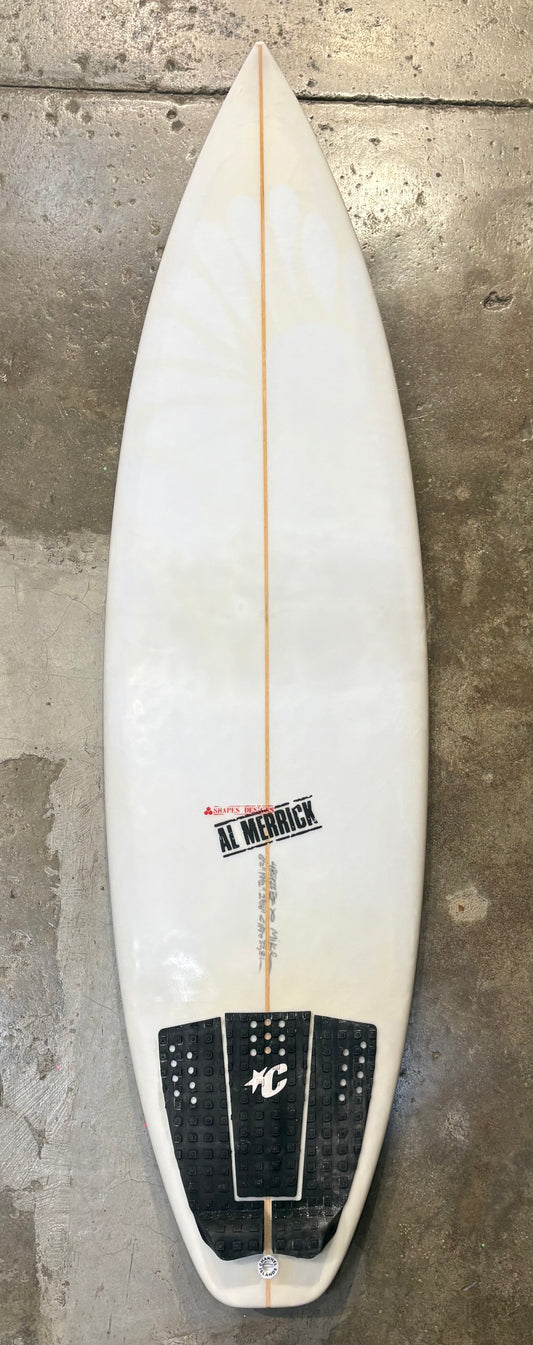 White Channel Islands - CI PRO  6'2 x 19 1/2  2 9/16     32.5L surfboard with black fins on a concrete wall background