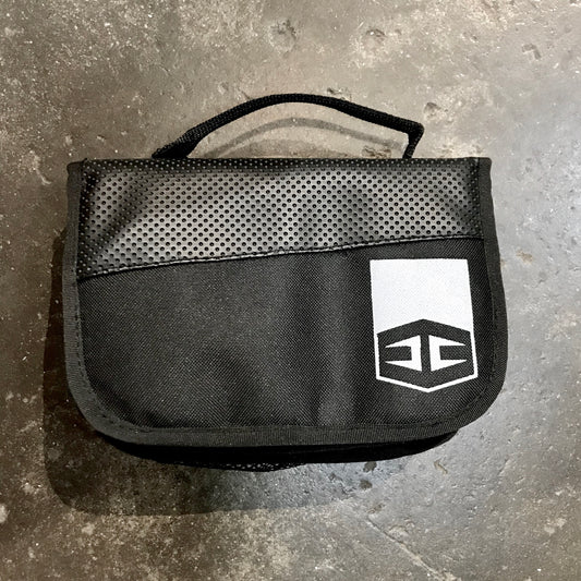 A  black Hurricane Fin Bag with a logo on a concrete surface.