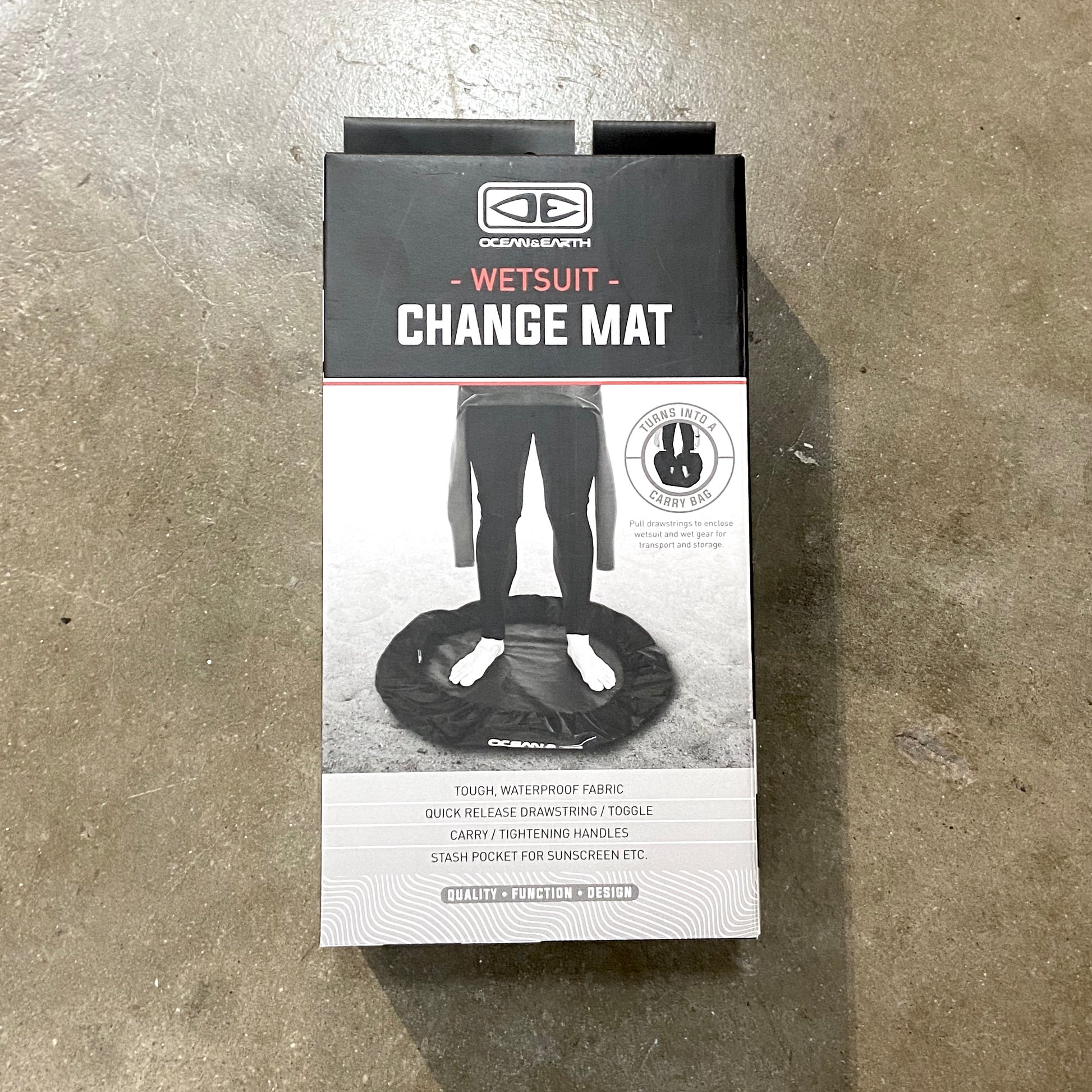 Packaged wetsuit change mat with the OCEAN&EARTH brand visible on the packaging, designed for laying out and changing into wetsuits.