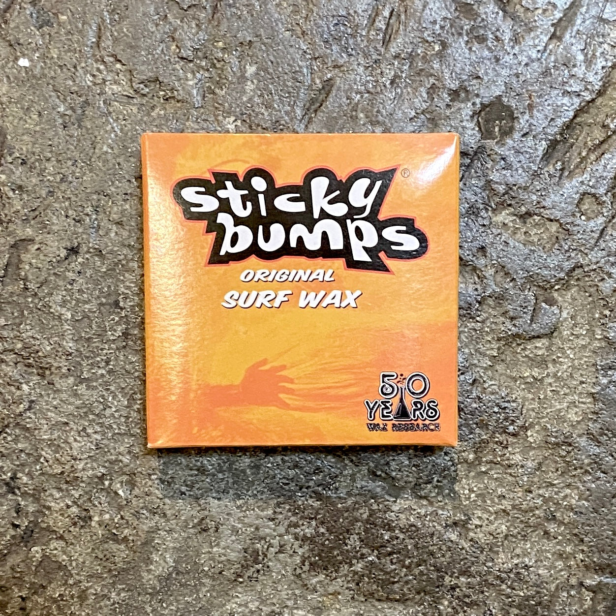 Sticky Bumps Surf Wax on a concrete surface