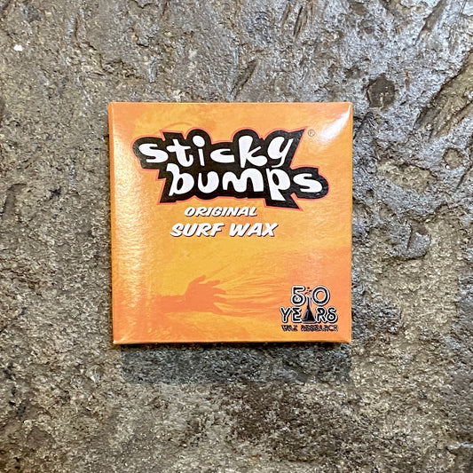 Sticky Bumps Surf Wax on a concrete surface